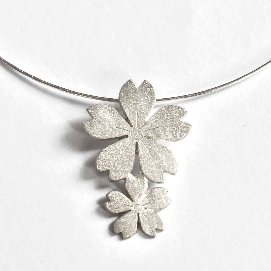 Two cherry blossoms on silver cord